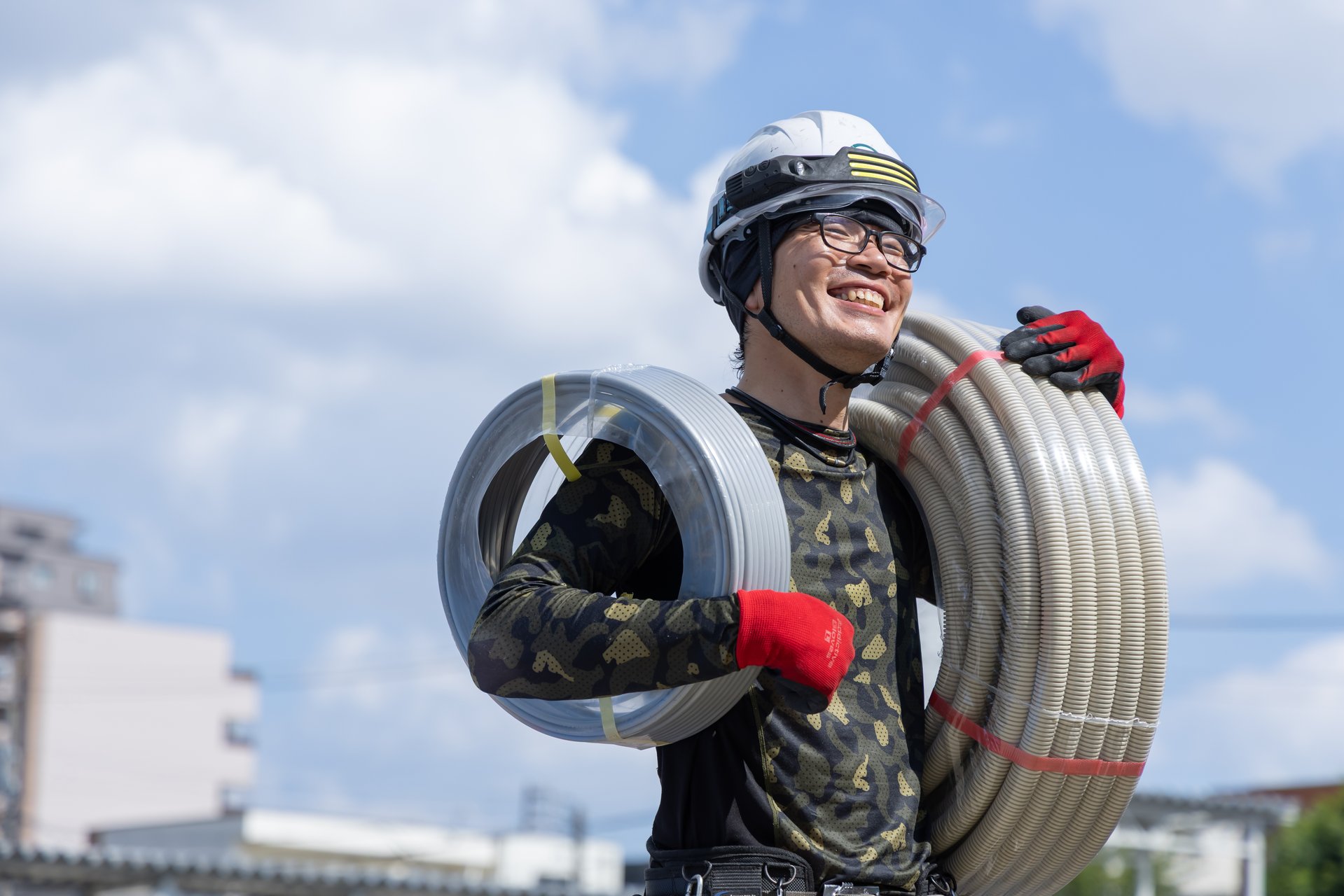 笑顔で資材を運ぶ三野屋電工スタッフ