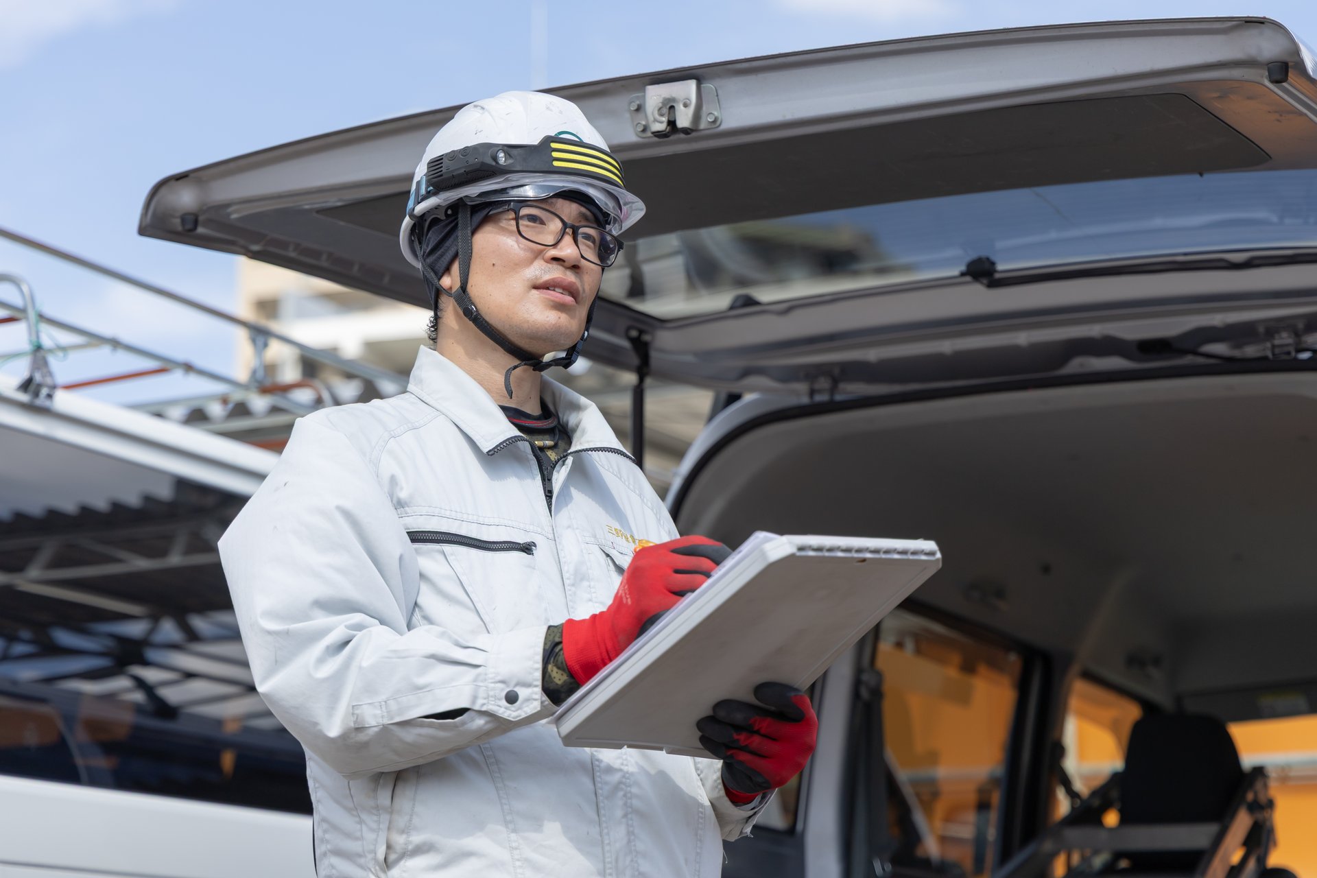 クリップボードを持ち現場を確認するスタッフ